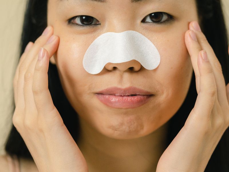 Phụ nữ châu Á dán miếng lột mụn mũi chăm sóc da dầu, lỗ chân lông