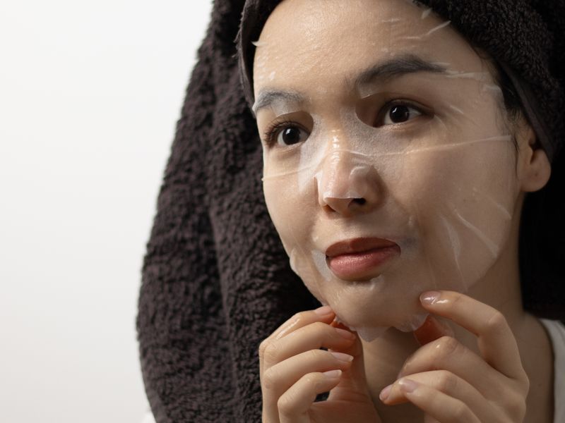 Người mẫu châu Á đắp mặt nạ giấy cấp ẩm cho da thiếu nước