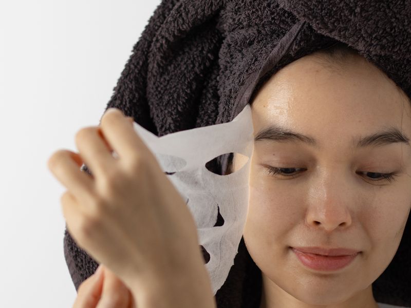Phụ nữ châu Á đắp mặt nạ làm dịu cho da đỏ giãn mao mạch tại nhà