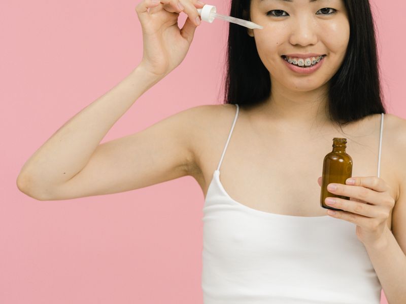 Cô gái châu Á dùng serum hỗ trợ se khít lỗ chân lông to tại nhà